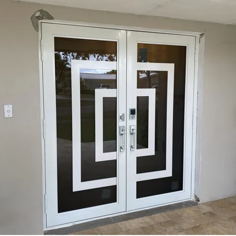 White double impact door with a decorative geometric pattern on the glass and a keypad lock