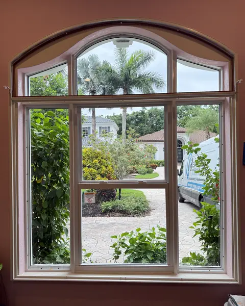 Inside view of an arched fixed impact transom over impact windows facing the driveway in Palm Beach County