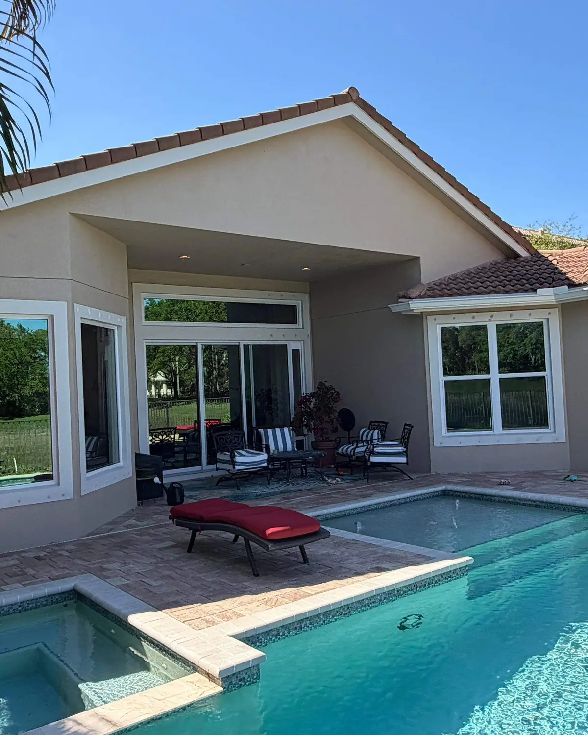 Panoramic fixed picture impact windows overlooking a Palm Beach luxury pool patio