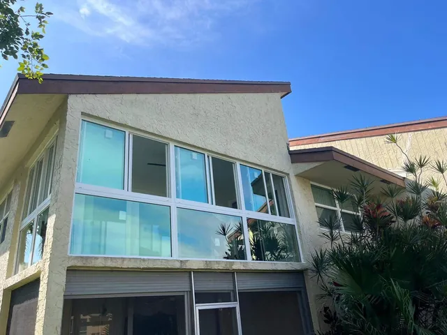 Exterior corner view of a second-story impact glass Florida room enclosure with Low-E solar control glazing