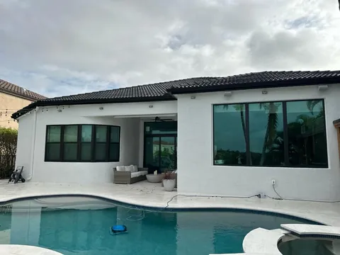 Pool side of a home with black-frame impact windows and an impact sliding glass door