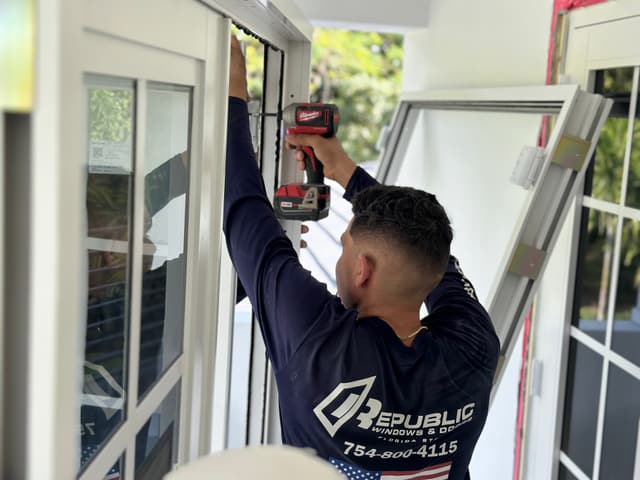 Installer drilling an impact window frame on a Republic job